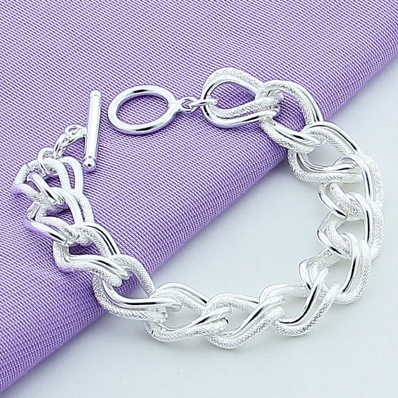 Silver chain bracelet on a purple fabric background