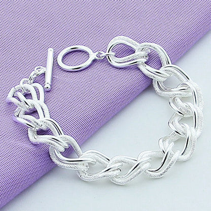 Silver chain bracelet on a purple fabric background