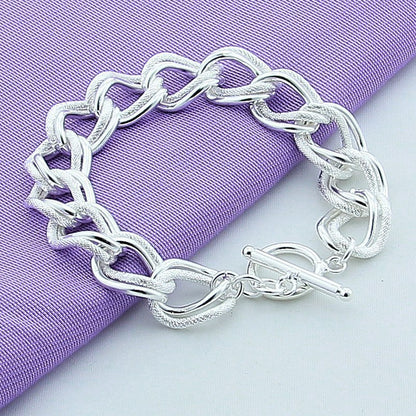 Silver chain bracelet on a purple fabric background